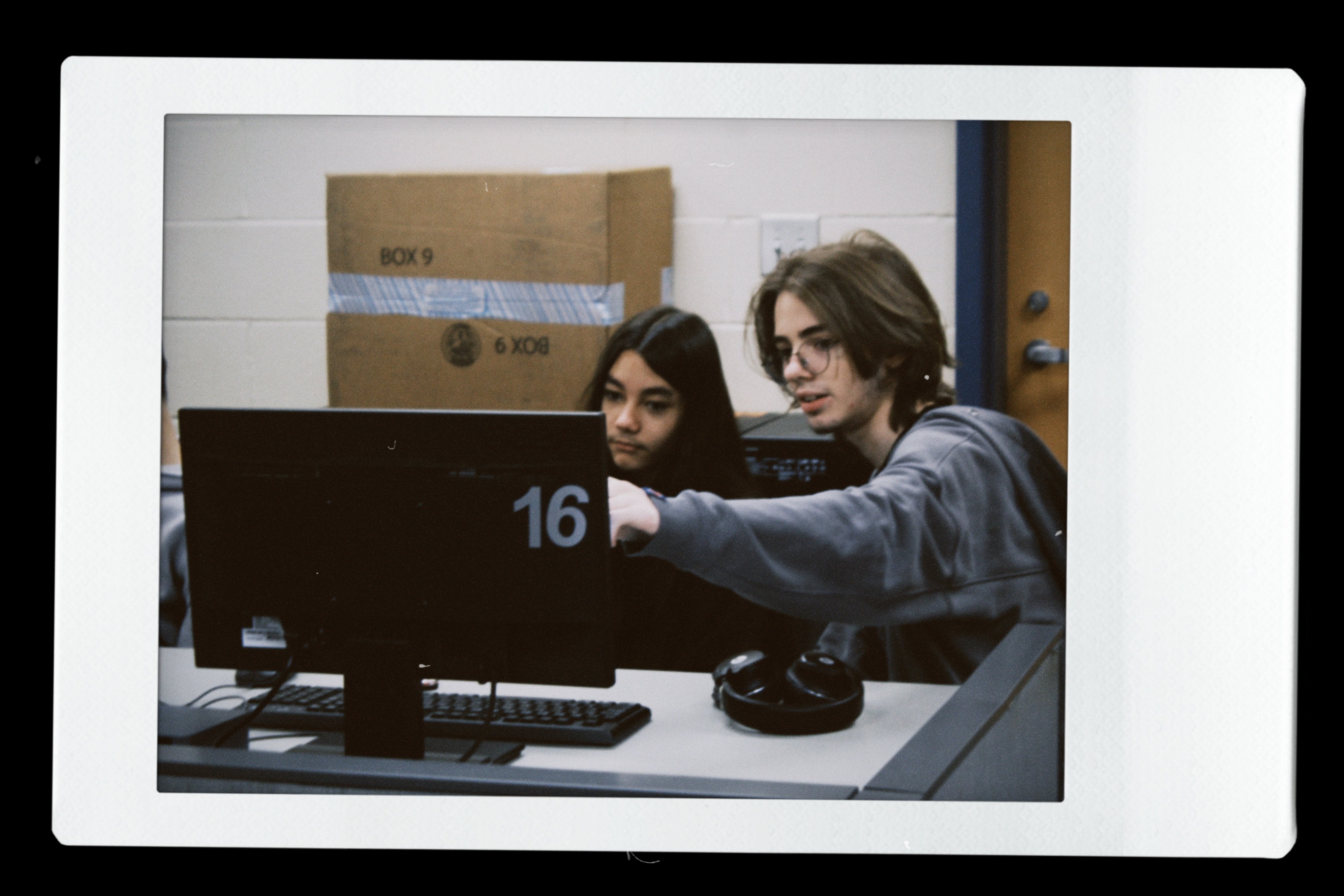 Students presenting beside a projector screen